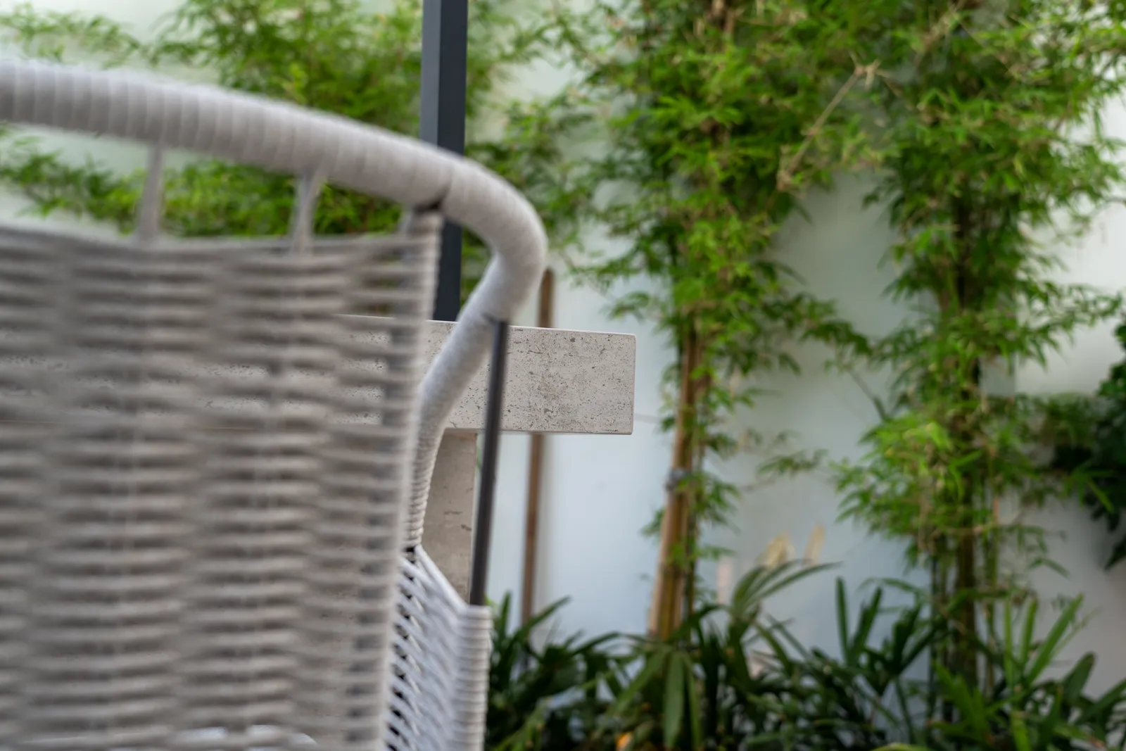 Detail of woven outdoor furniture against greenery