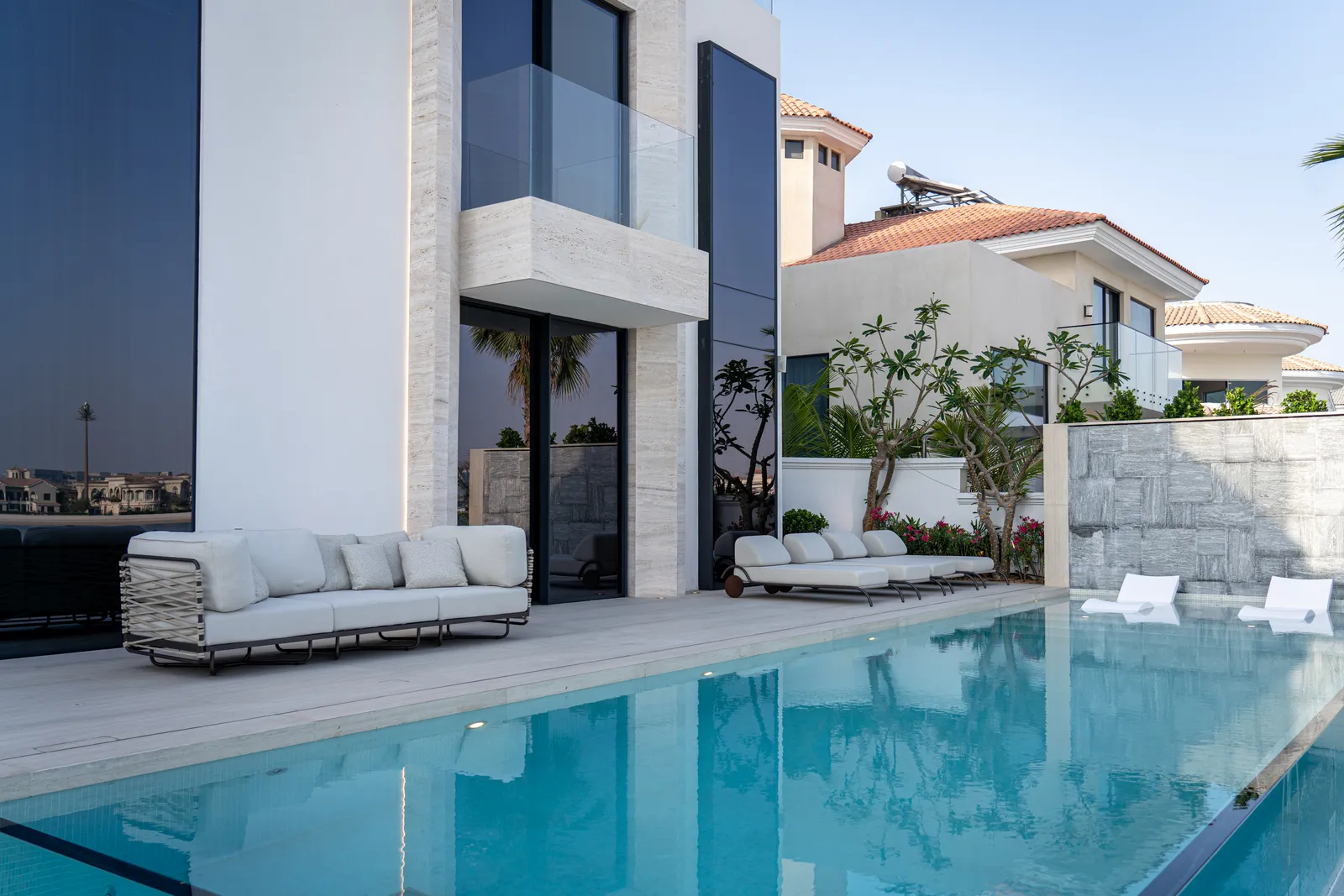 Poolside seating set against the villa facade