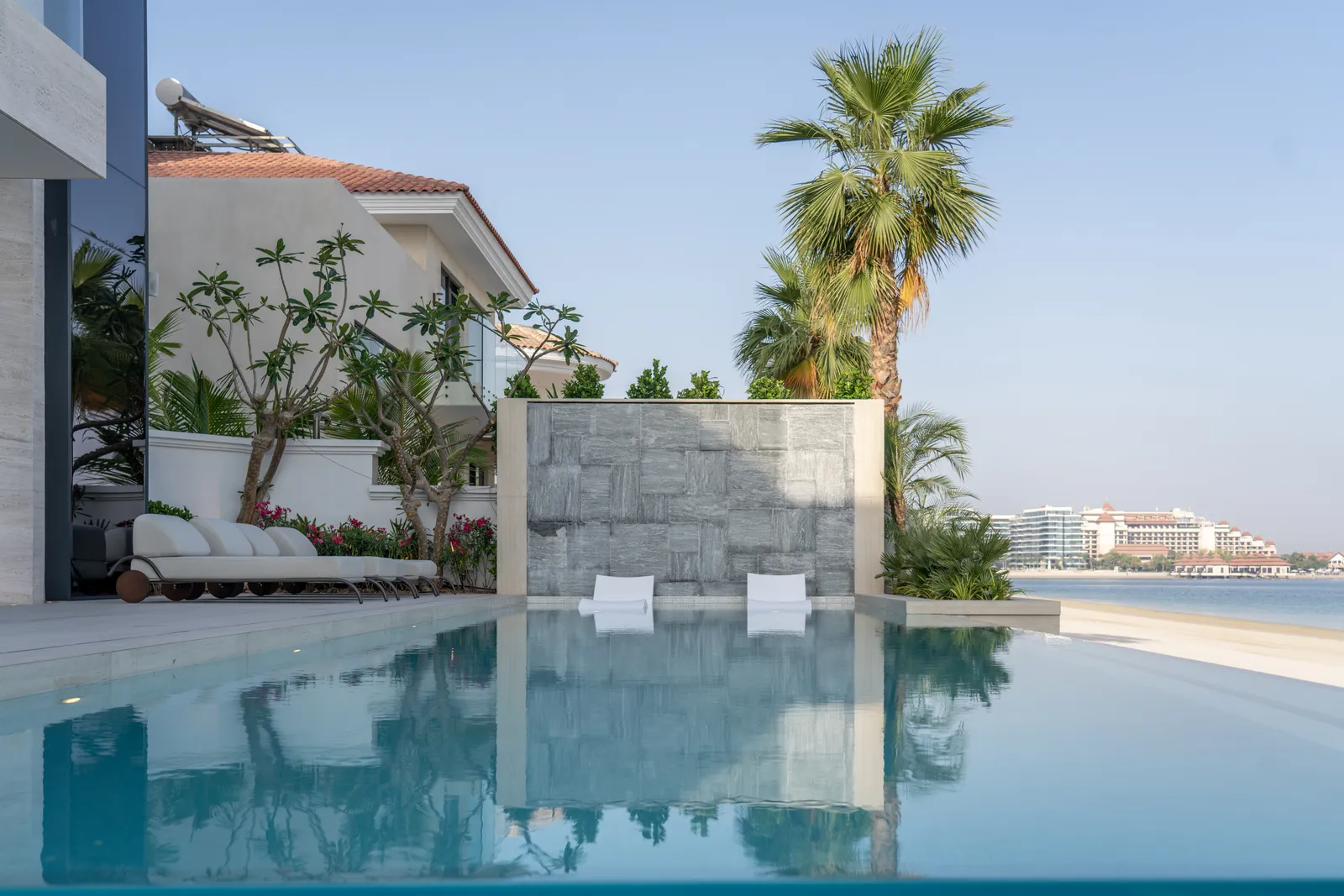 Pool terrace with palms and the Dubai skyline beyond