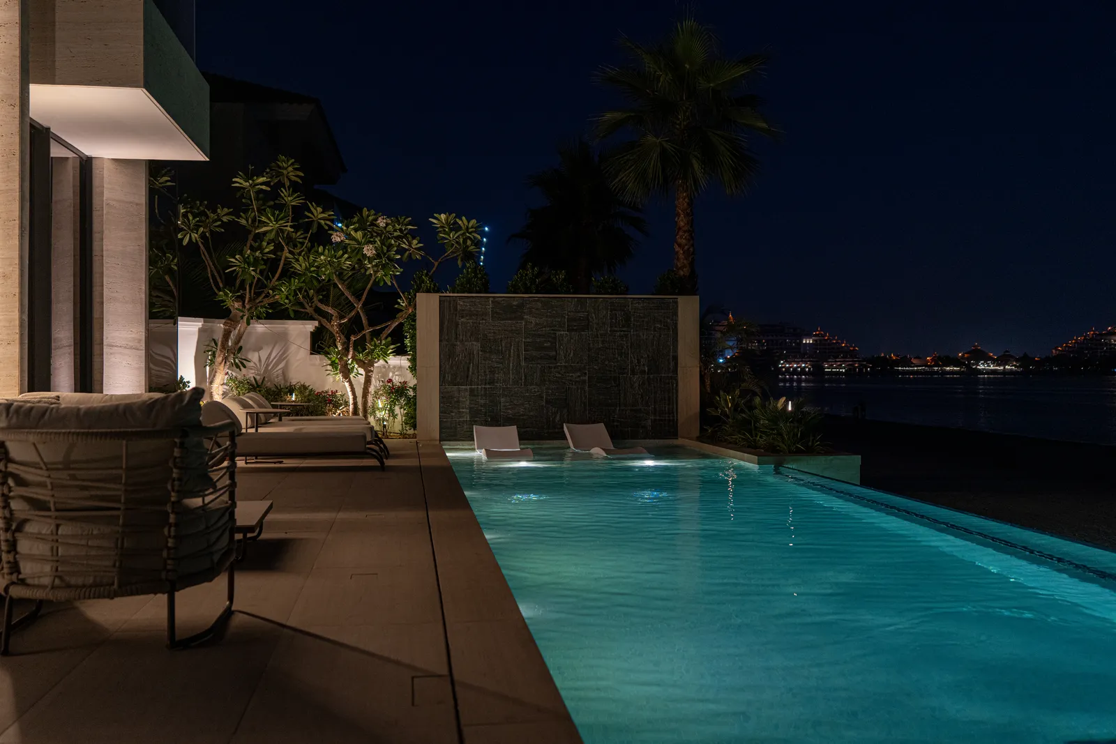 The pool lit at dusk with the city lights beyond