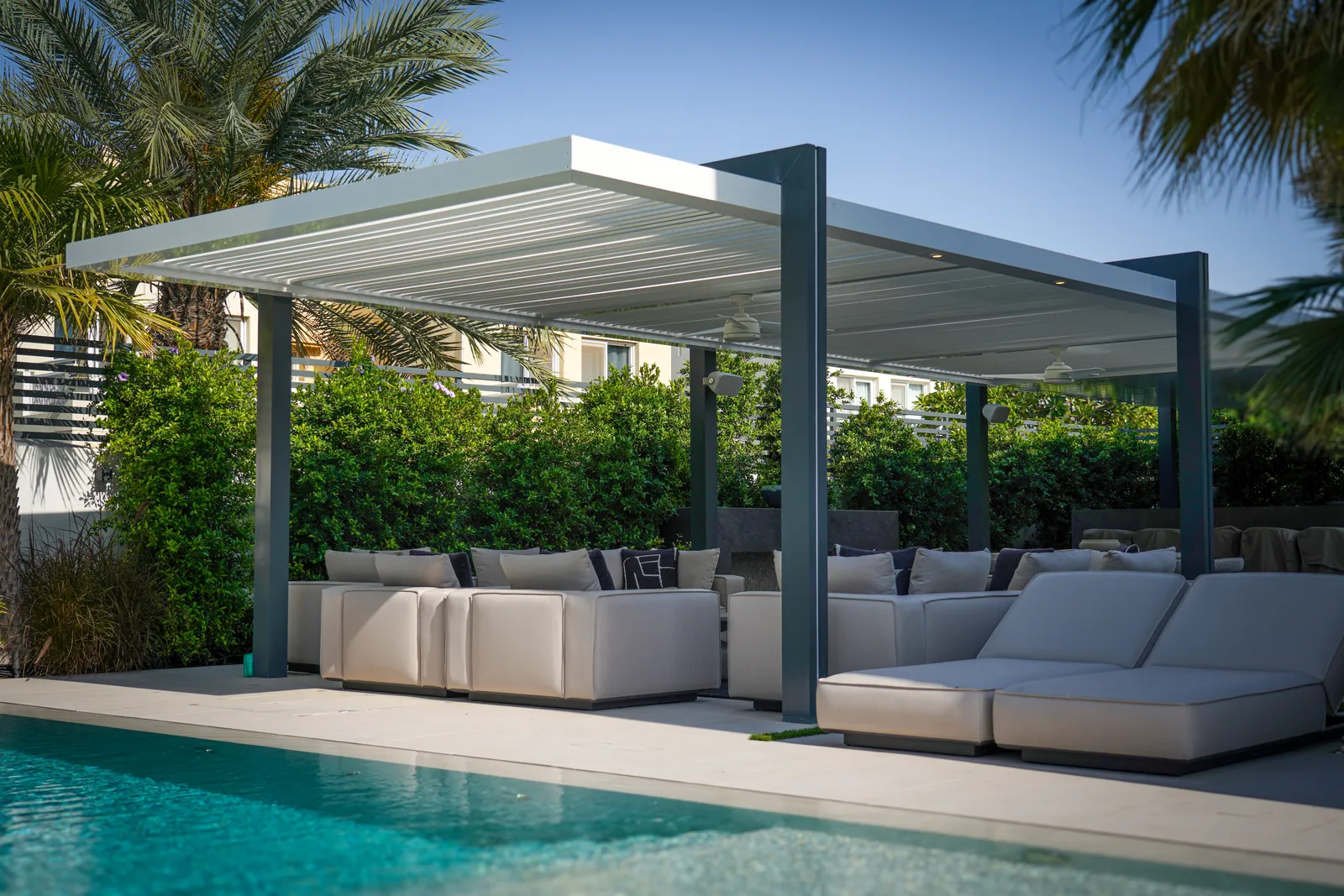 White pergola and daybeds along the pool
