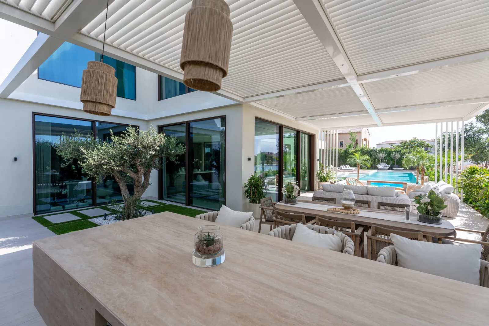 Covered terrace with dining and lounge areas beside the pool