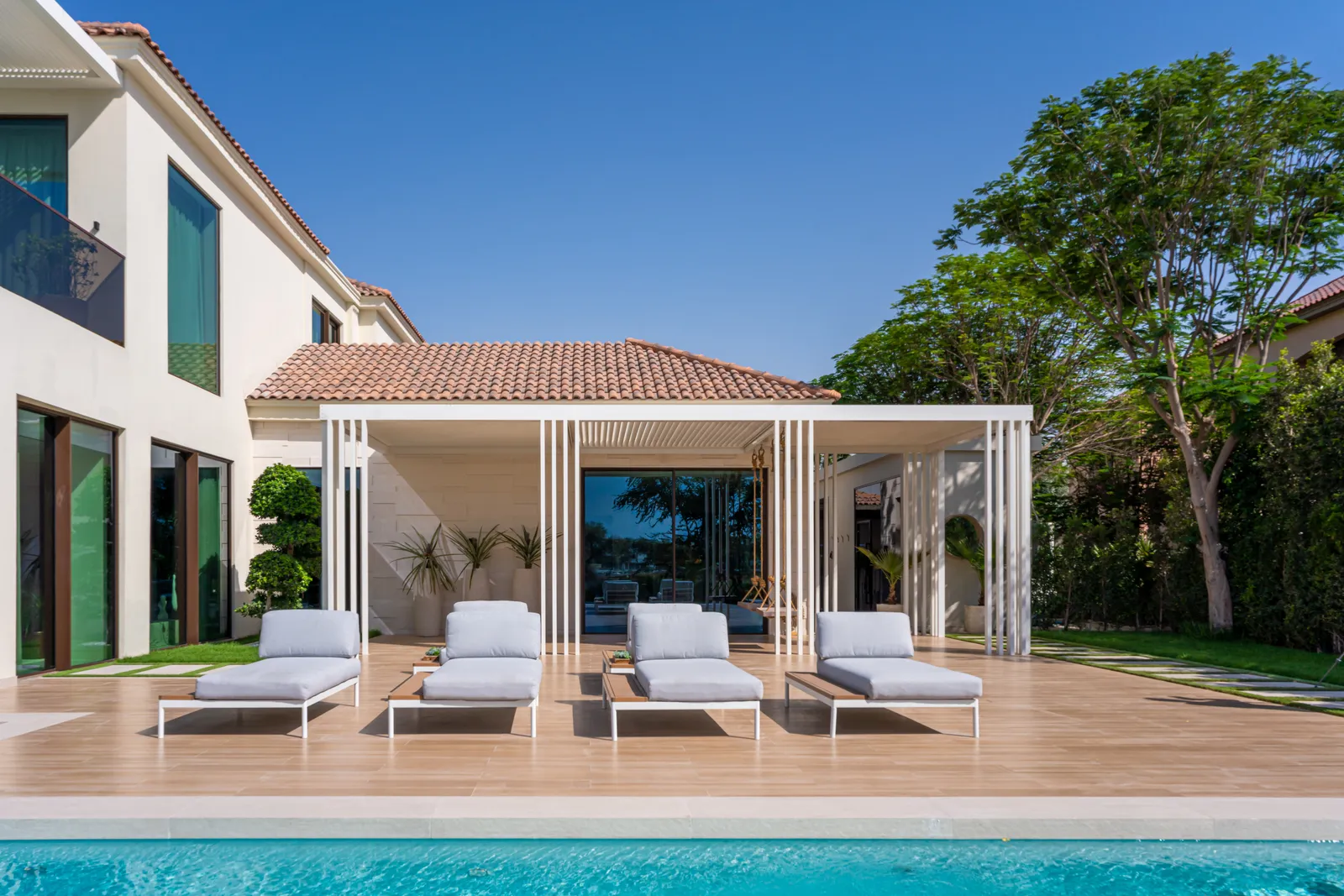 Pool and poolside pavilion with sun loungers