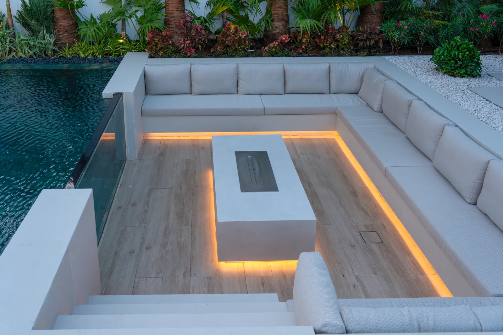 Sunken lounge around a lit fire table at dusk
