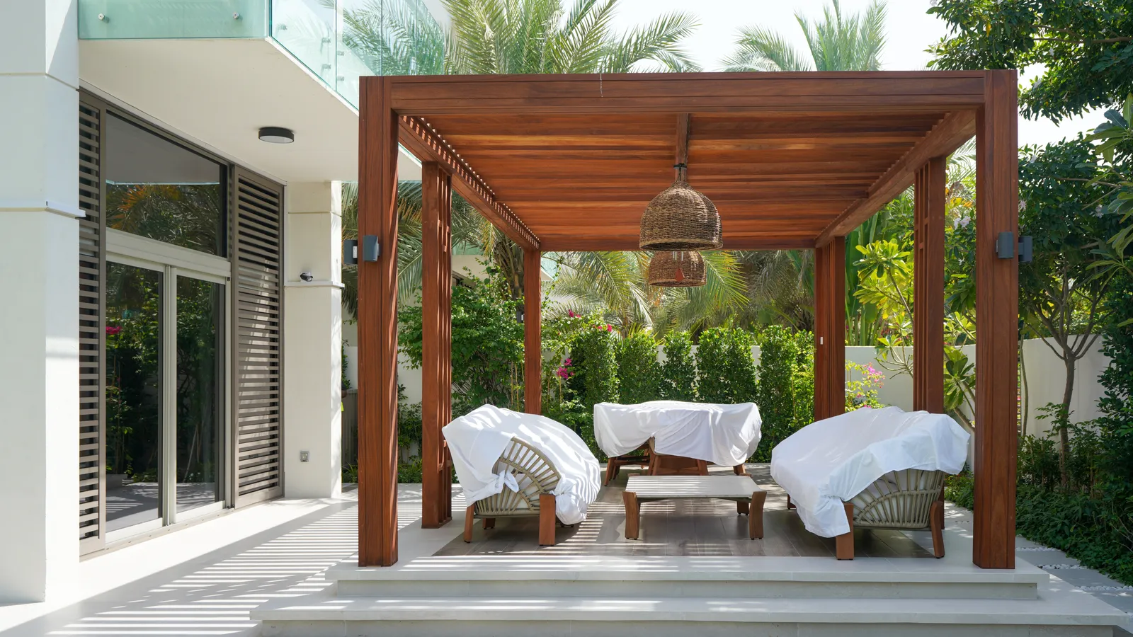 Teak pergola with hanging lanterns over the terrace lounge