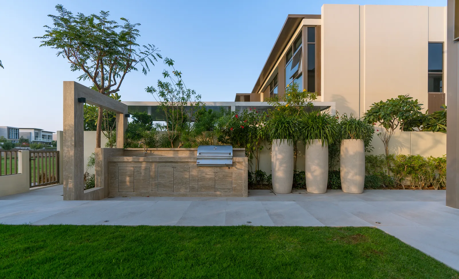 Built-in barbecue counter with tall sculptural planters