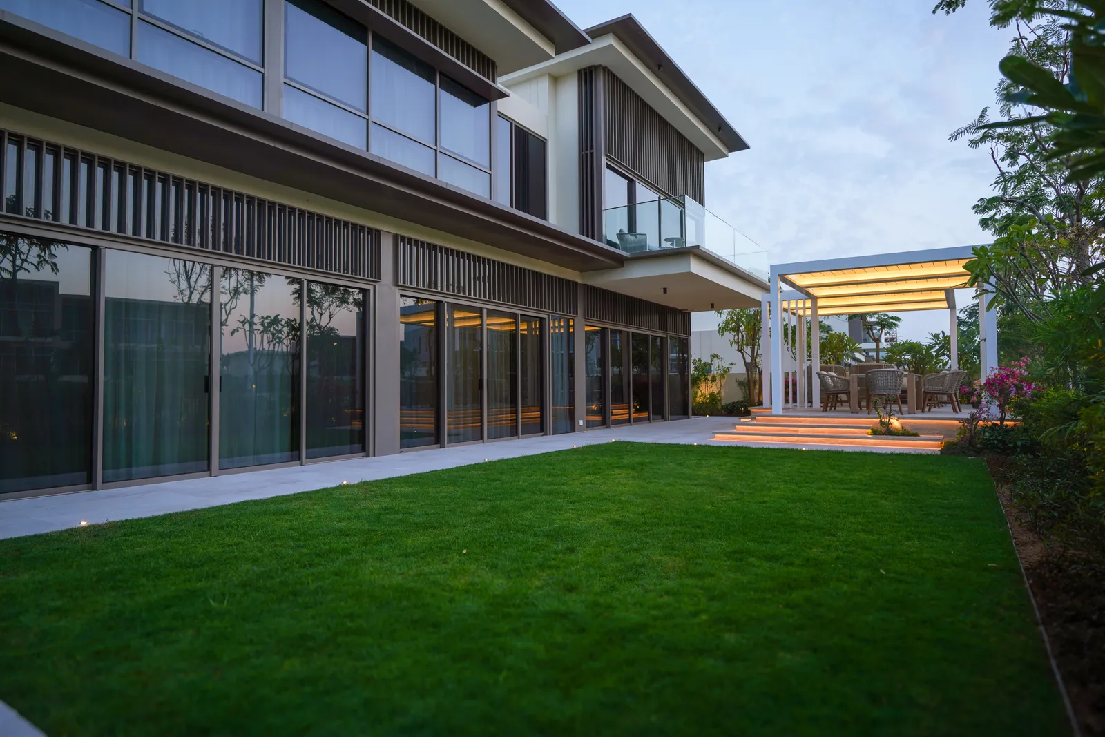 Wide lawn running up to the villa and its pergola